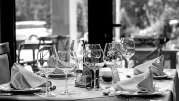 Restoran masasında özenli sunum, logo detayları ve güçlü marka kimliğini yansıtan şık bir yemek konsepti