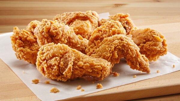 Servis tabağında farklı çıtır tavuk çeşitleri: kanat, nugget, tender ve burger; yanında çeşitli soslar.