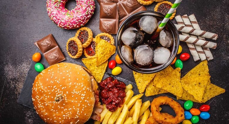 Hamburger, patates kızartması ve içecekten oluşan klasik fast food menüsünün yer aldığı iştah açıcı bir masa.