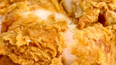 Panko ile kaplanmış çıtır tavuk pane dilimleri, yanında ketçap-mayonez sosları ve limonla servis edilmiş.
