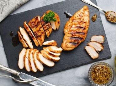 Izgara tavuk göğsü, taze sebzeler ve dengeli bir öğün sunumuyla yüksek proteinli beslenmeyi simgeleyen tabak