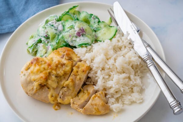 Tavuk yemeğinin yanında pilav, patates, salata ve közlenmiş sebzelerle hazırlanan uyumlu ve iştah açıcı sofra